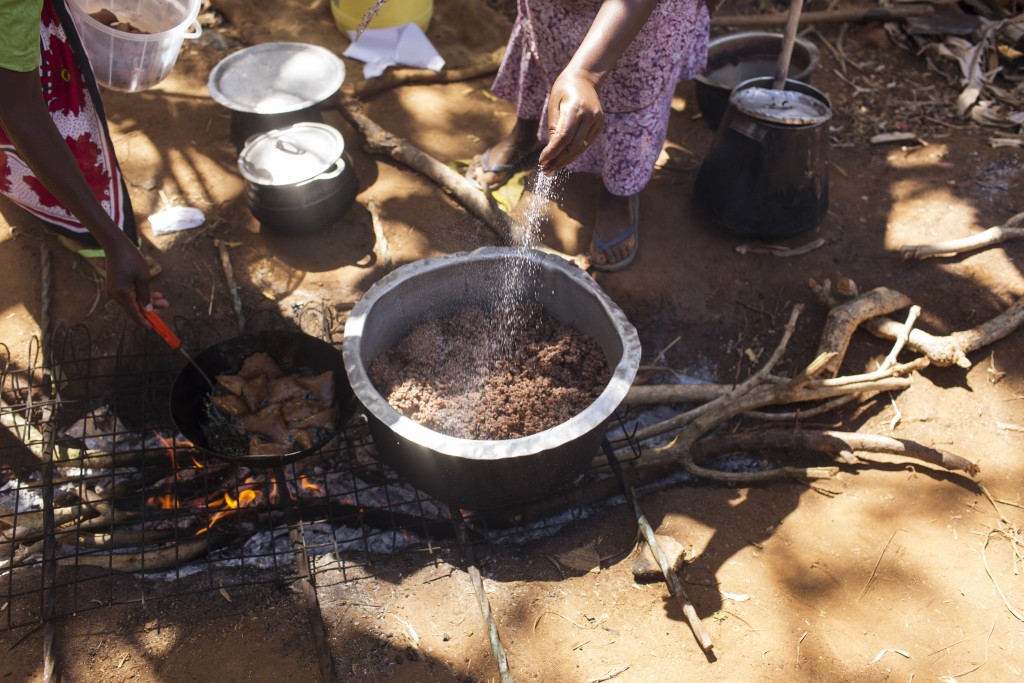 Cecilia Mwikali Kyalo cooking sorghum at home, Kiatine Village, Kenya