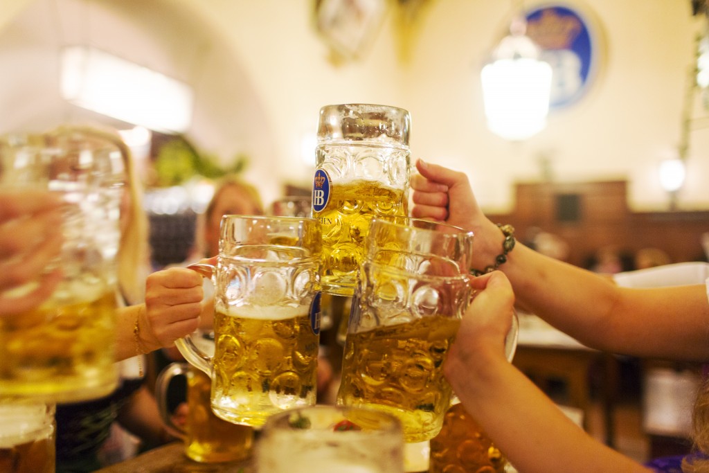 Friends on a pre-wedding 'Hen Party' make a toast with beers at the Hofbrauhaus, Munchen, Germany