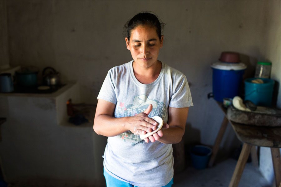 Cecilia at home making tortillas for her children. 
